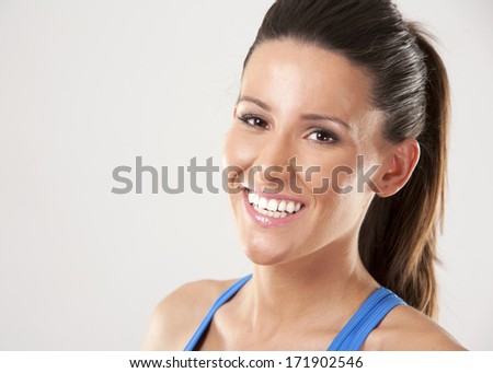 fitness model brunette wearing blue outfit on light background