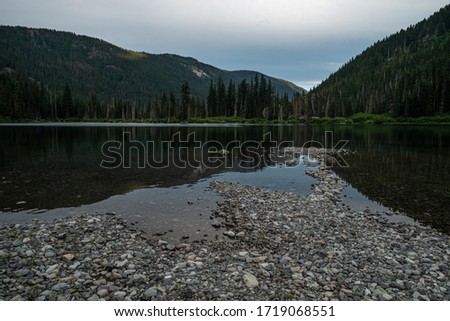 Lake in forest between mountains
