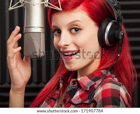 young pretty woman recording on audio studio