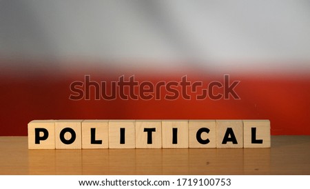 POLITICAL message word on a wooden desk on cube blocks with a polish flag background
