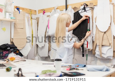 Fashion designer woman working on her designs in the studio. Creative workspace
