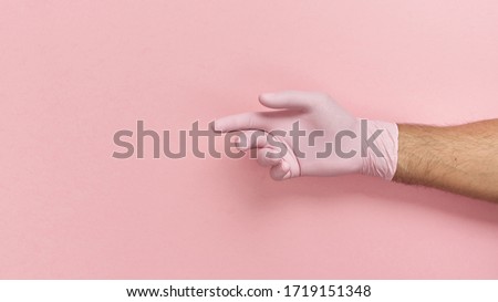   Hand gesture in a disposable glove, protection against viruses.                             