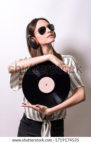 Portrait of a beautiful girl with vinyl and headphones
