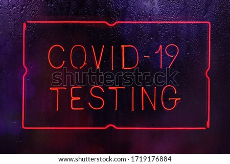 Covid-19 Testing Neon Sign in Rainy Window
