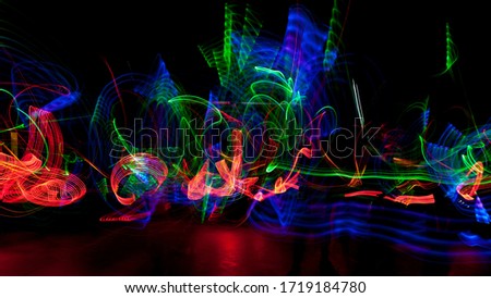 Long exposure photograph creates an abstract and futuristic painting color texture with neon lighting effect. Modern, creative and dynamic shiny pattern, on a black background. energy lines abstract 