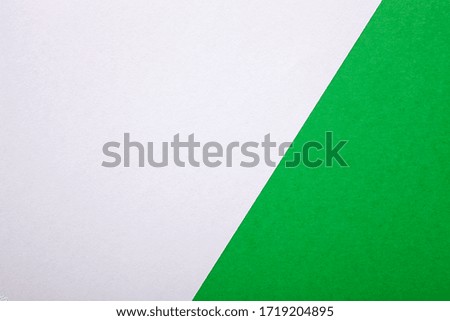 Green and white paper as background. Two colored bright paper texture, top view with place for text