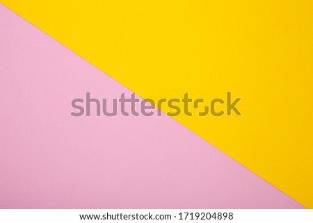 Pink and yellow paper as background. Two colored pastel paper texture, top view with place for text