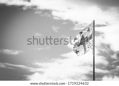 Black and white background image of Waving georgian flag with with clouds and sky in the background. Concept of economics and georgian pplotics.2020