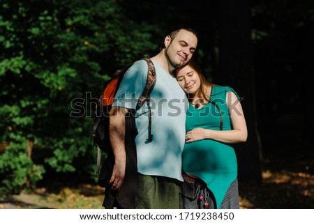 Man and pregnant woman in summer park