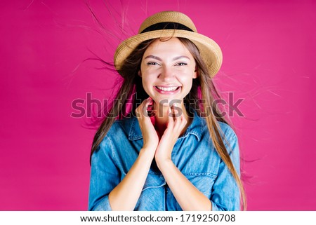 a summer resident in a hat laughs joyfully touching her fingers on her chin