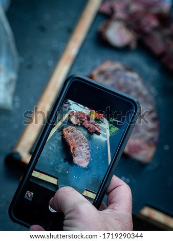 Taking a picture of a steak with a smartphone for social media