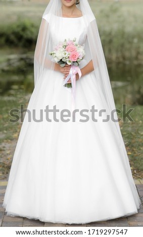 bride in wedding dress holds wedding bouquet