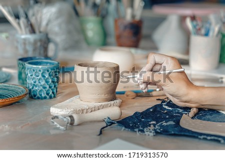 girl craftsman working with earthenware product for sale in her shop. Pottery business concept for an artist concept
