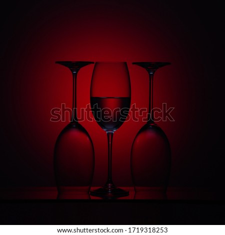 Three glasses for wine on a red background.