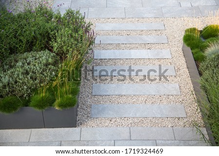 Garden and terrace design with a modern mix of construction material and precious garden decoration objects and various plants or foliage plants Royalty-Free Stock Photo #1719324469
