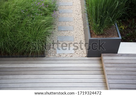 Garden and terrace design with a modern mix of construction material and precious garden decoration objects and various plants or foliage plants Royalty-Free Stock Photo #1719324472