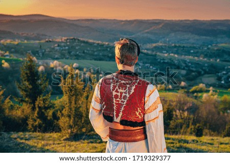 Traditional Folk dress in spring morning landscape. Hrinova, Slovakia