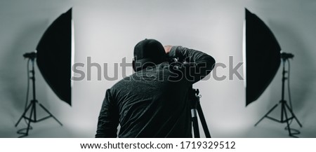 Professional photographer taking picture with lighting equipment in studio