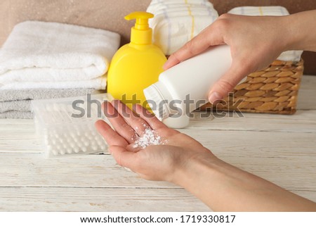 Mom applying talc powder from plastic tube. Baby hygiene Royalty-Free Stock Photo #1719330817
