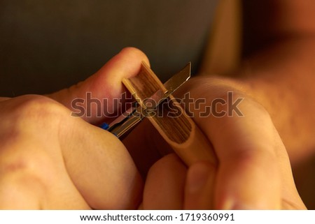 Skilled calligrapher hand crafting a bamboo pen, calligraphy tool making art Royalty-Free Stock Photo #1719360991