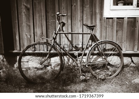 Old rusty bicycle on a wooden wall. Black and white photography