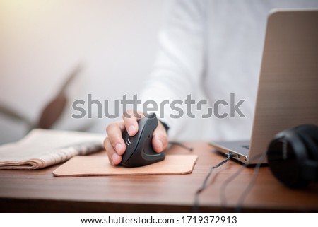 The man working from home. Close up at the hand and ergonomic computer mouse. Working during COVID-19 concept. Royalty-Free Stock Photo #1719372913