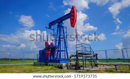 Oil pump jack at the plain. Industrial background.