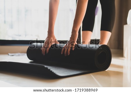 Woman practicing yoga and meditating indoors. Beautiful girl preparing material for practice class. Calmness and relaxation. Female happiness and yoga concept. Royalty-Free Stock Photo #1719388969
