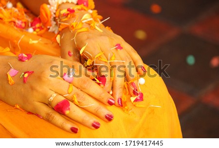 a picture of a bridal hands soaked in turmeric milk and flower petals during an Indian Hindu wedding ritual 