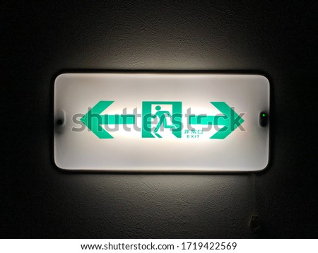 Emergency exit sign with electric light in building. Safety system guidance of building.
