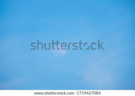 Moon by daylight in a cloudy sky