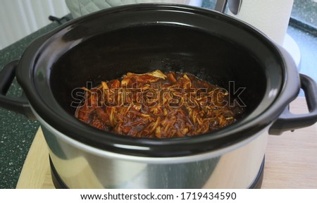 View of pulled chicken cooked in a crock pot.