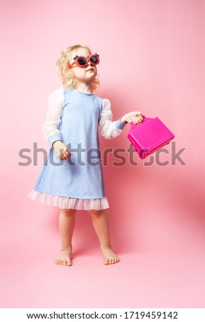 Little girl child in sunglasses with a pink redicle.