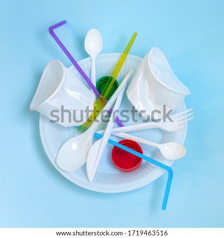 Plastic waste, plastic utensils on a blue background,flat lay. Say no to single use plastic. Ecology environmental care.Copy space for text.