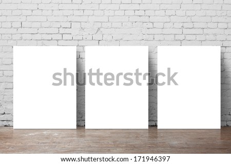 three  poster standing next to a brick wall