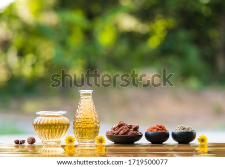 Organic  herbal  oil  extraction  from  various  herbs  in  glass  bottles  on  wood  table  with  nature  blurry  background  for  the  health  concept
