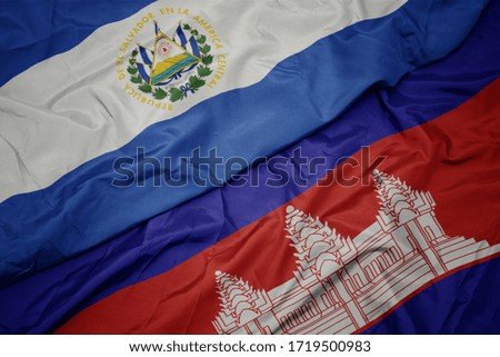 waving colorful flag of cambodia and national flag of el salvador. macro