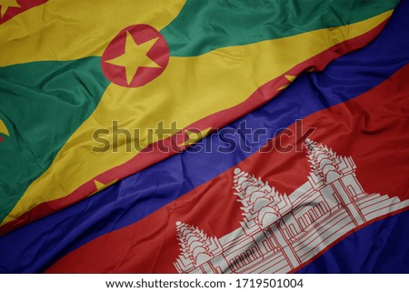 waving colorful flag of cambodia and national flag of grenada. macro