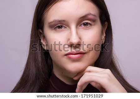 Studio emotional portrait of a beautiful young brunette woman with natural make-up 