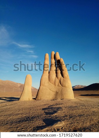 Hand of the desert. Emotional symbol of vulnerability, helplessness and loneliness of a person in the sand. Royalty-Free Stock Photo #1719527620