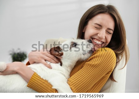 Young woman with her cute Jack Russell Terrier at home. Lovely pet Royalty-Free Stock Photo #1719565969