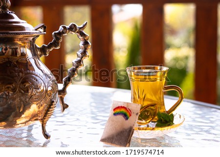 Arabic teapot and a cup of tea with peppermint and a rainbow painted on a tea bag