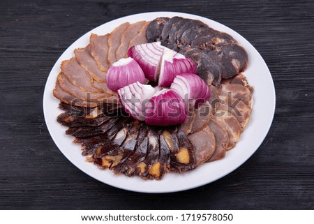 Meat plate with meat stock with red onions