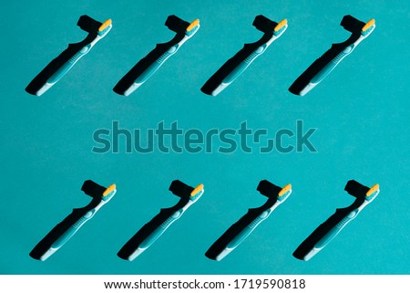 Plastic toothbrushes on a blue pastel background. Pattern
