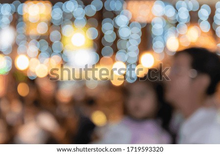 Abstract and blur images of Father carrying his daughter to walk to the night market with bokeh background, to family time concept.