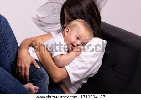 Portrait of young woman and little child id denim isolated on white background. Mother's care, tenderness and love for her daughter. Portrait of beautiful baby-girl. Mother's day.
Happy child.