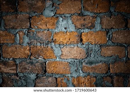 An old brick wall with remnants of cement between the seams. Construction materials, creative background.
