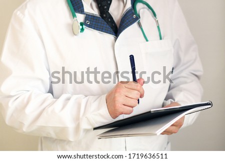 Doctor pediatrician writes a medical history, makes a diagnosis. Coronavirus. Banner panorama, medical staff, preventive equipment. Pandemic.  Healthcare concept