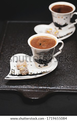 traditional Turkish coffee with Turkish delight. heart shaped saucers and traditional Turkish coffee on black granite   tray in black background. Coffee cups and saucers with the symbols of istanbul.