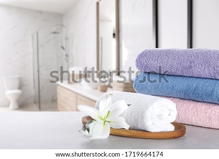 Fresh towels and lily flower on light grey marble table in bathroom. Space for text Royalty-Free Stock Photo #1719664174